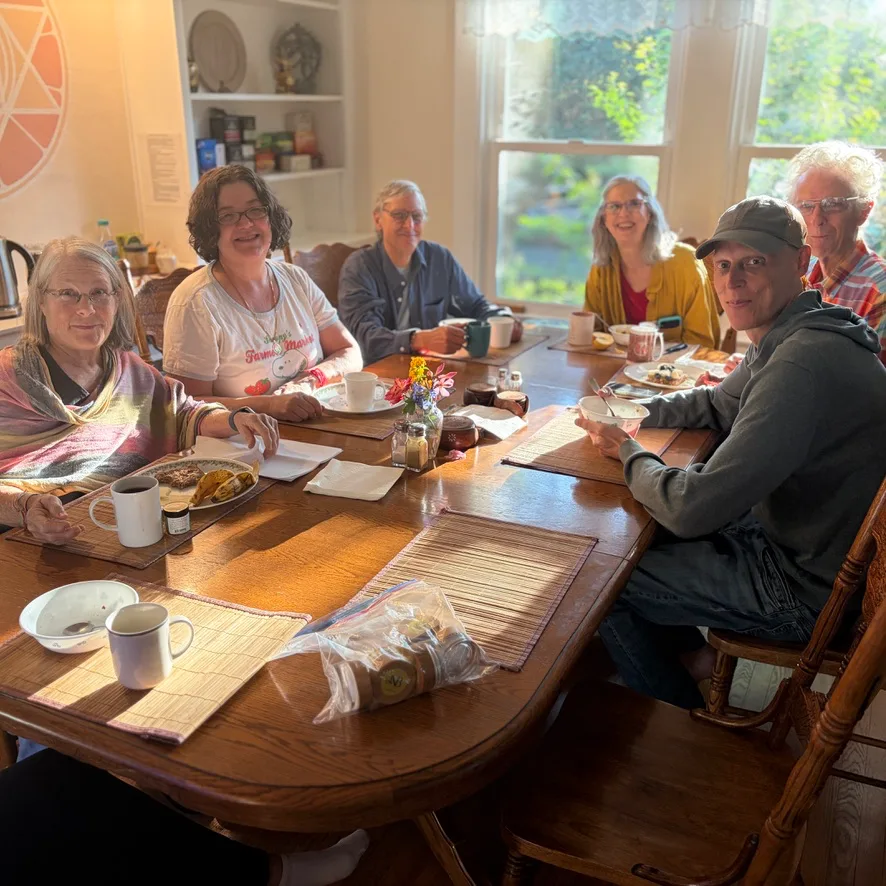 AVI USA board members around the table, reviewing partner reports indoors at Sri Aurobindo Sadhana Peetham