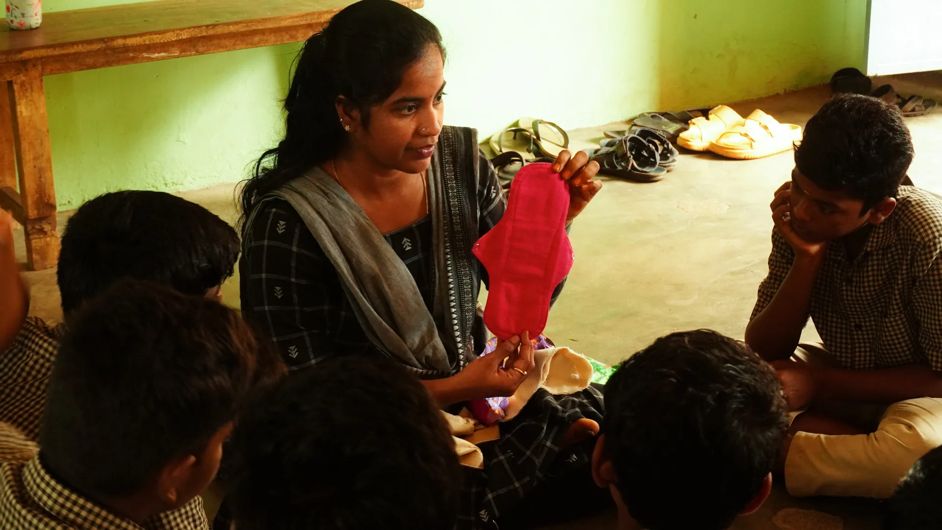 Kalvi Period Ally showing a reusable pad to a Boys Group