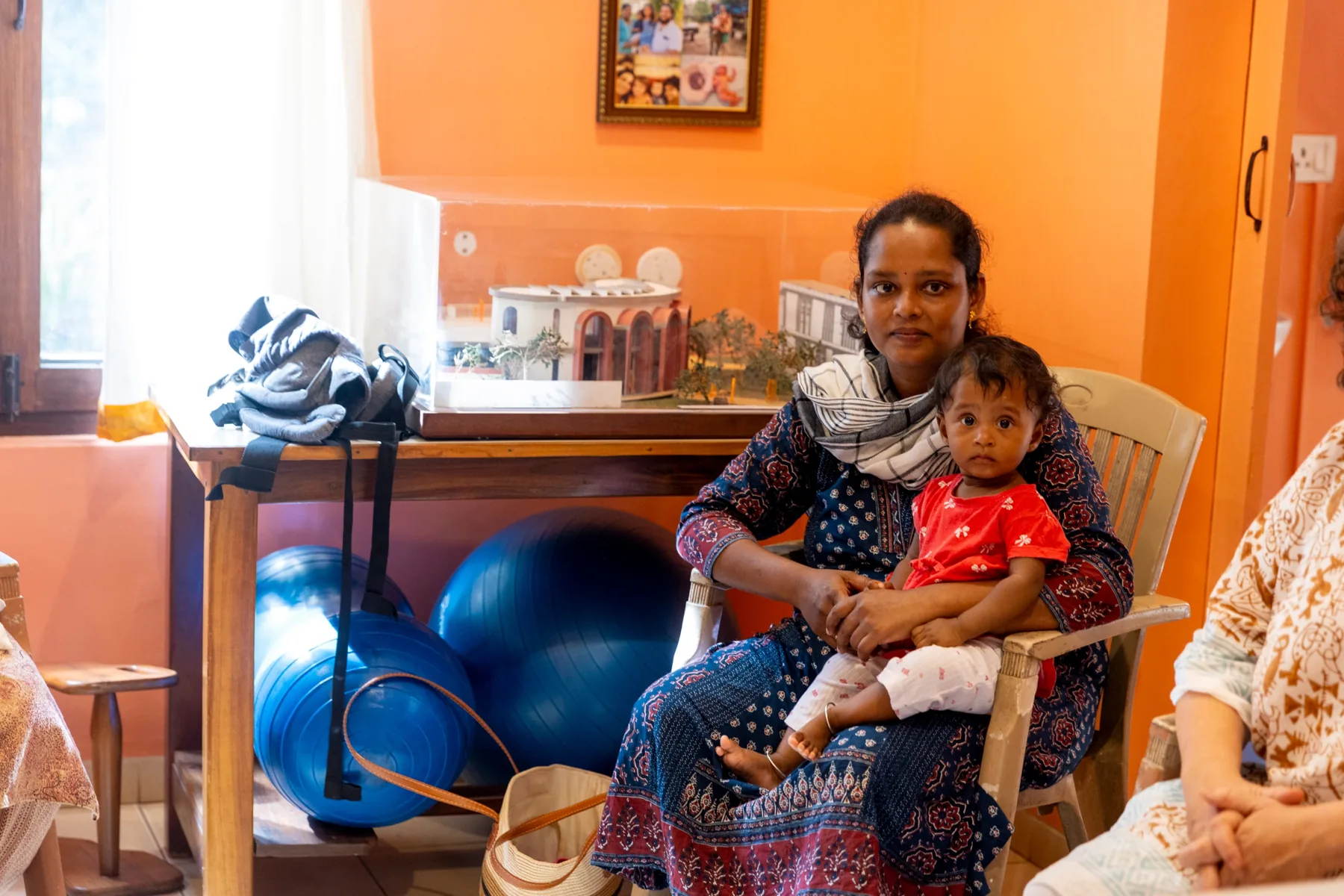 A mother holding her baby on her lap in the MorningStar office