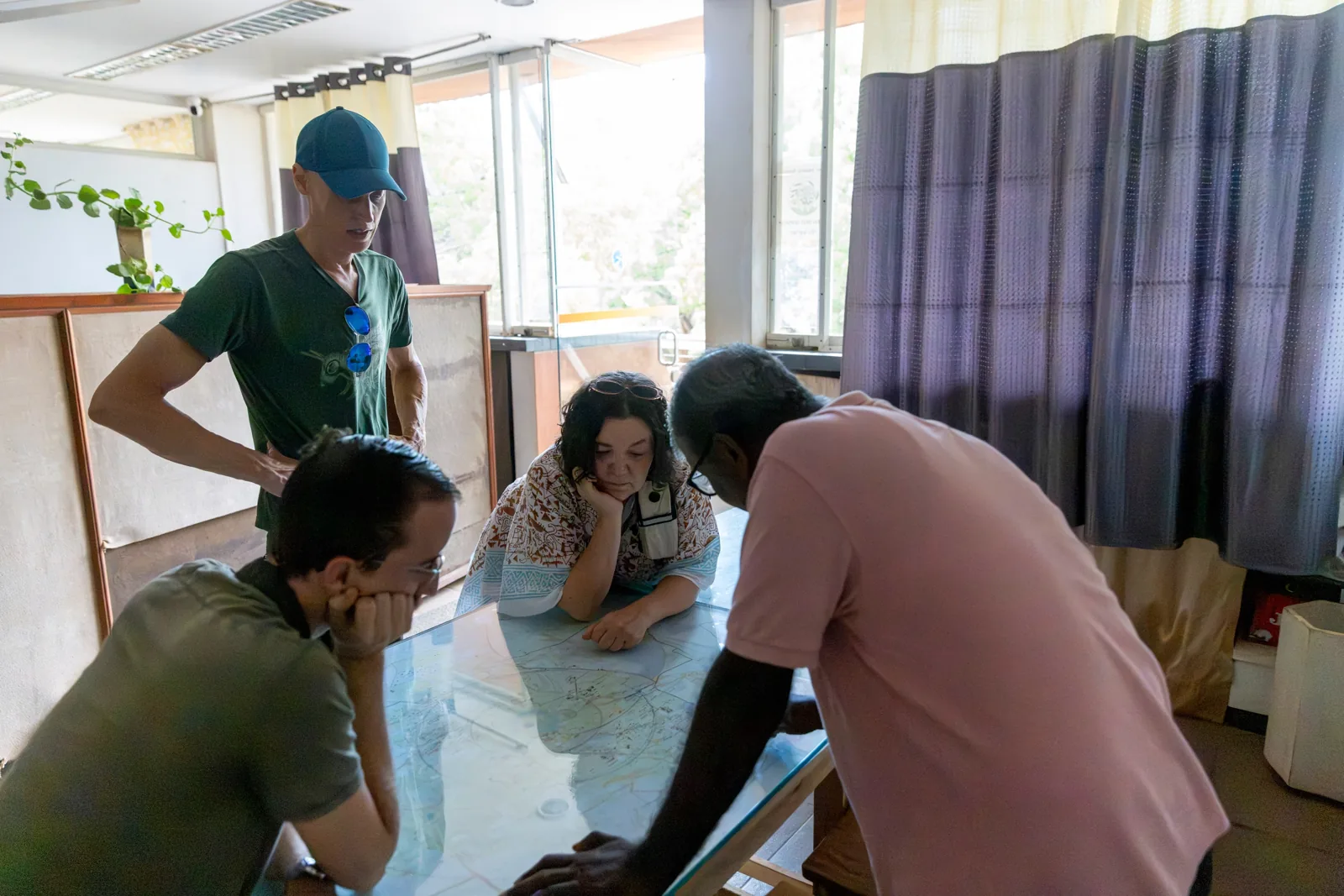 Visitors and a partner studying a large map of the Auroville area