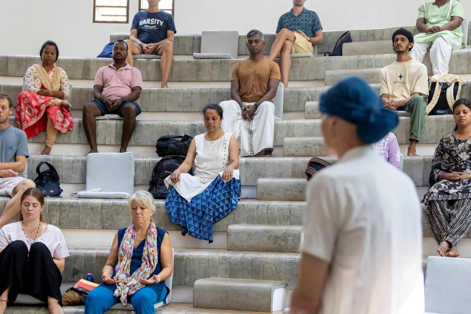 Participants seated on the steps of the hall at Savitri Bhavan
